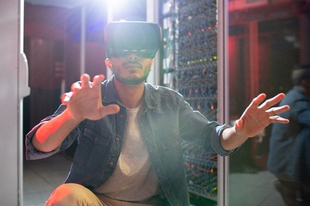 IT engineer studying server systems using VR goggles