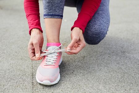 Tying Pink Sports Shoe