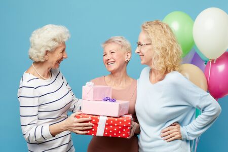 Lady friends congratulating birthday womanの写真素材