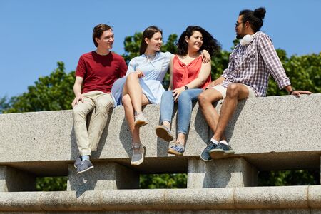 Friends Sitting on Concrete Wallの写真素材