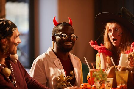 Multi-ethnic group of friends wearing costumes having fun during Halloween party together, copy spaceの写真素材