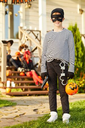Full length portrait of cute teenage boy dressed as bandit posing outdoors on Halloween, copy spaceの写真素材