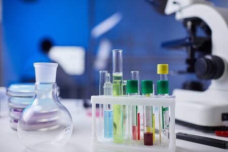 Close up of assorted glassware and test tubes with blood samples on table in medical laboratory,...
