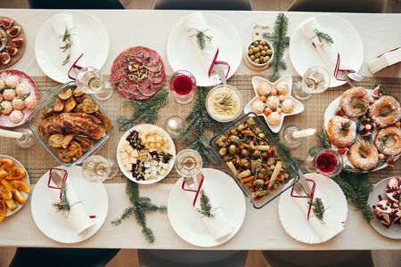 Top view background of beautiful Christmas table with delicious homemade food decorated with fir branches, copy spaceの写真素材