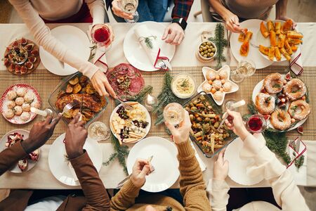 Top view background of people dining at festive Christmas table with delicious homemade food, copy spaceの写真素材