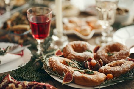 Close up of delicious homemade pastry with crystal glass of wine set on dining table decorated by fir tree branches on Christmas, copy spaceの写真素材