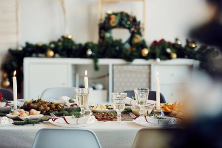 Background image of beautiful table setting for Christmas party with fir elegant candles and delicious homemade food, copy spaceの写真素材