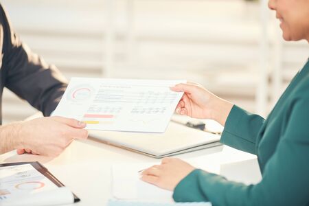Closeup of unrecognizable businessmen handing documents during business meeting in office, copy spaceの写真素材