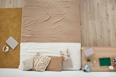 Above view background of cozy bed in home interior with warm-toned beige covers, copy space