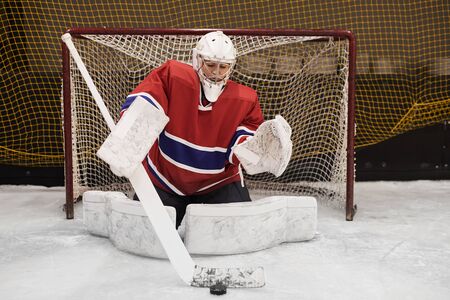 Full length portrait of female hockey player defending gate in full gear, copy spaceの写真素材