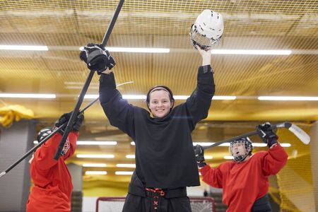 Portrait of female hockey team cheering while celebrating victory on skating rink, copy spaceの写真素材