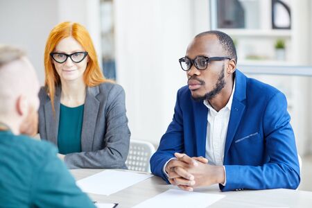 Portrait of contemporary African-American businessman listening to candidate during job interview in officeの写真素材