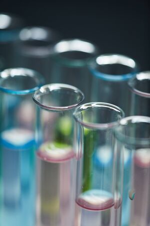 Extreme close up background of test tubes with colored liquid on table in research laboratory, copy spaceの写真素材