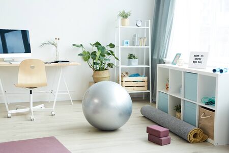 Background image of various sports equipment on floor in small apartment studio, home workout concept, copy spaceの写真素材