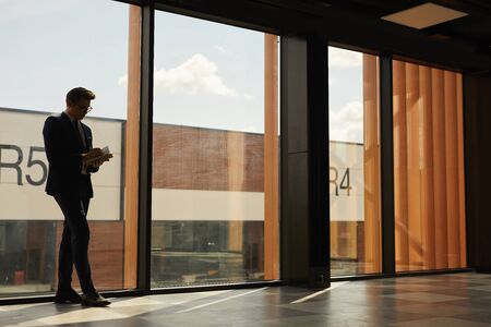 Wide angle view of empty contemporary building with floor to ceiling windows and outline of rental agent indoors, copy spaceの写真素材