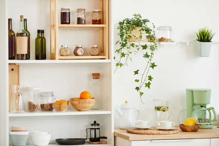Background image of cozy kitchen interior with wooden shelves for spices and utencils decorated with plants, copy spaceの写真素材