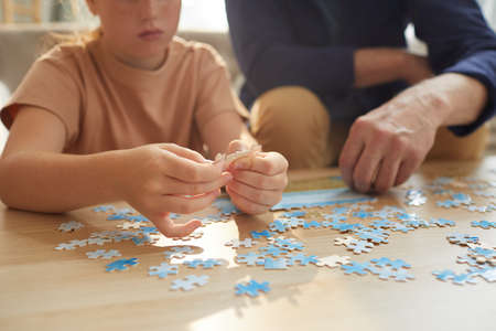 Warm toned close up of unrecognizable girl playing board games with grandparents while enjoying time together, copy spaceの写真素材