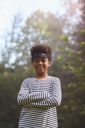 Vertical waist up portrait od smiling African-American boy dressed as bandit for Halloween whiole...