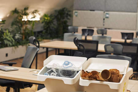 Background image of two waste sorting containers for plastic and cardboard on desk in modern office interior, copy spaceの写真素材