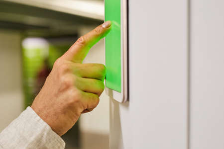 Close up of unrecognizable man using touch pad with green screen while operating self storage unit, copy spaceの写真素材
