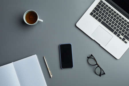 Above view flat lay of laptop and business accessories on grey workplace background, copy spaceの写真素材