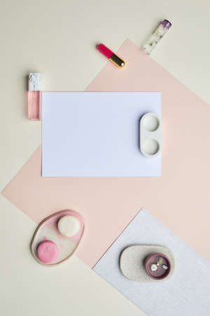 Minimal graphic composition of blank white paper and makeup on pastel-colored background, copy spaceの写真素材