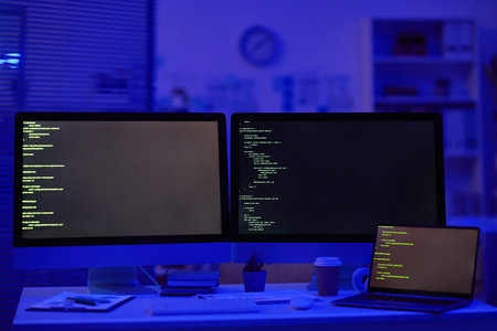No people shot of desktop computer with two monitors and laptop on table in office room belonging to professional programmerの写真素材