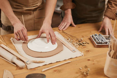 Close up of unrecognizable male artisan making ceramics in pottery workshop, copy space
