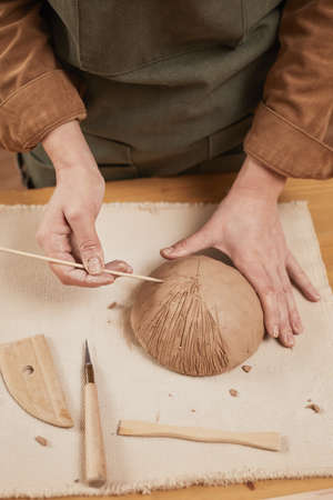 High angle close up of young woman making ceramic bowl in pottery workshop, small business concept,...