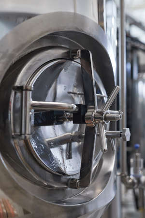 Vertical close up of vault lock on storage tank in industrial workshop, copy space