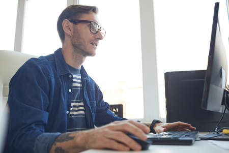 Male IT Developer Using Computer Side Viewの写真素材