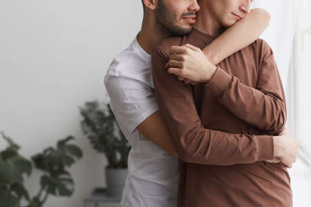 Loving Gay Couple Embracing at Homeの写真素材