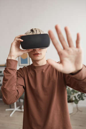 Young Man Playing VR and Reaching Outの写真素材