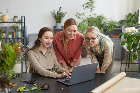 Portrait of three young woman using laptop in flower shop while managing small business, copy spaceの写真素材
