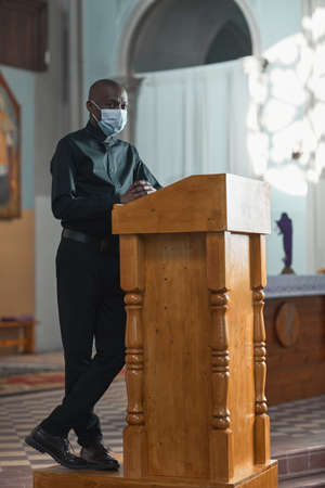 African man in mask performing during mass in the churchの写真素材