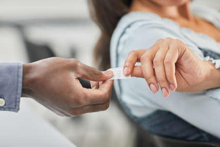 Close up of two students passing cheat note sneaking during exam in school, copy spaceの写真素材