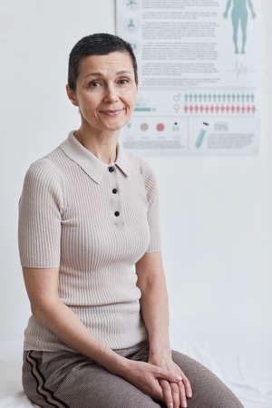 Portrait of mature woman looking at camera while visiting doctor at doctors office
