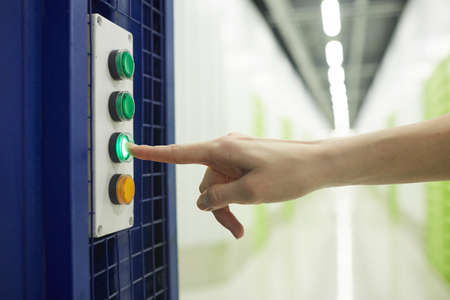 Close-up of woman pushing the button on the elevator