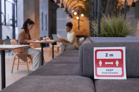 Background image of restaurant interior with focus on social distancing sticker, copy space