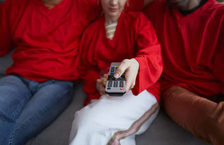 Group of sports fans holding remote control while watching game match at home, close up, copy spaceの写真素材