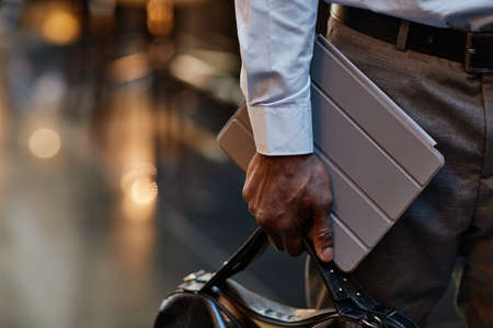Close up of successful businessman carrying digital tablet and briefcase, copy spaceの写真素材