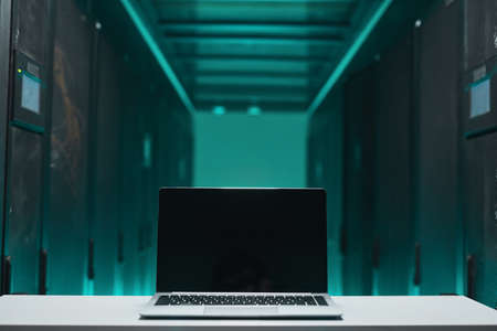 Background image of opened laptop with blank screen in futuristic server room, supercomputer concept, copy spaceの写真素材