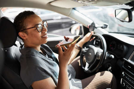 Driver sitting in the car and talking on mobile phone during her driving