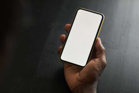 Close-up of man holding mobile phone with empty touch screen