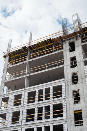 Vertical shot of residential building under construction with brick and concrete structure, copy...