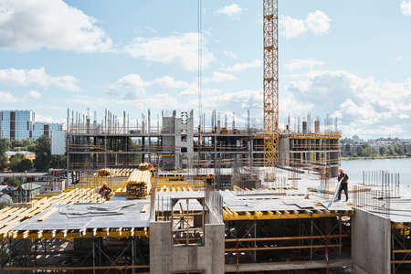 Wide angle view at construction site with unfinished residential buildings against blue sky, copy...