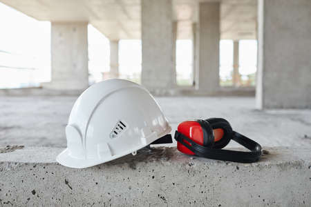 Background image of white hardhat and tools on floor at construction site, copy space