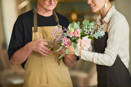 Cropped shot of two florists arraigning flower compositions in cozy workshop, copy spaceの写真素材