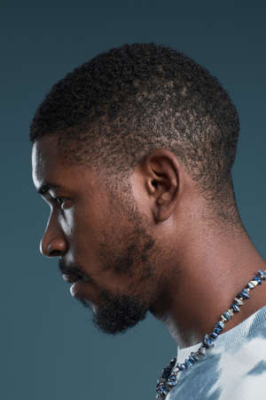 Close up side view portrait of handsome African-American man against blue, focus on profile outlineの写真素材