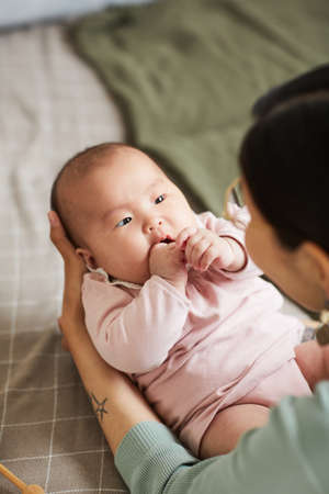 Close-up of little girl looking at her mother while she playing with her childの写真素材